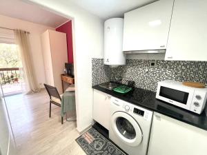 a kitchen with a washing machine and a microwave at THE Estoril Studio in Estoril