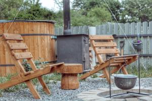 a wooden chair and a grill in a backyard at Woodlandia Resort Borjomi in Borjomi +73 photos