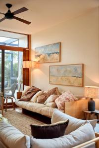 a living room with two couches and a ceiling fan at Hygge by the Ocean - Aireys Inlet in Aireys Inlet