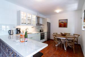 a kitchen with a table and a dining room at Villa Lorca Vista Mar by Casasol in Nerja