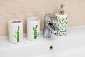 a bathroom sink with two cups and a faucet at Green cottage Baredi, Izola, Slovenia in Izola
