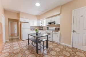 una cucina con un tavolo e un frigorifero bianco di NYC Train EWR Liberty Park 1 a Bayonne