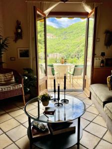 a living room with a glass table in front of a door at Casabellavista in Pigna, Liguria in Pigna