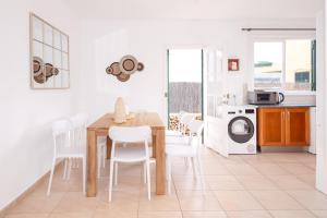 Una cocina y un comedor con mesa y sillas. en Villa Jultomas, en Cala'n Bosch