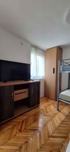 a living room with a flat screen tv and a wooden floor at Holiday home in Balatonmariafürdo 26831 in Balatonmáriafürdő