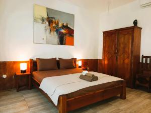 a bedroom with a bed and a painting on the wall at Wombat's B&B in Gili Trawangan