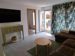 a living room with a couch and a table and a tv at Apartaments IXA in Manresa