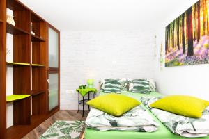 a room with two beds with yellow pillows in it at Green cottage Baredi, Izola, Slovenia in Izola