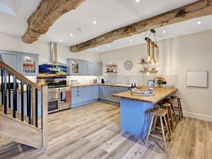 a kitchen with blue cabinets and a wooden floor at Broomy Barn Brompton Regis in Dulverton