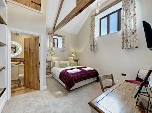a bedroom with a bed and a table in a room at Broomy Barn Brompton Regis in Dulverton