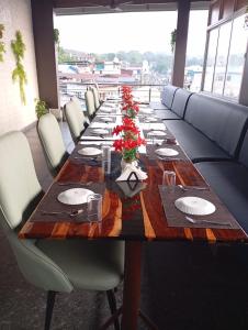 una mesa larga con sillas, platos y flores. en Hotel Landmark, en Port Blair