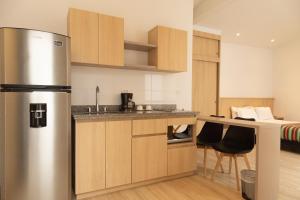 a kitchen with a stainless steel refrigerator in a room at Hotel Estar in Manizales