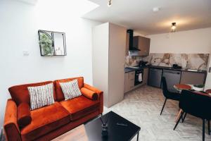 ein Wohnzimmer mit Couch und Küche in der Unterkunft Hen & Chickens Luxury Apartments, Free Parking, By DerBnB in Derby