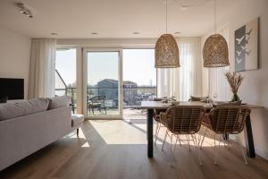 a living room with a table and chairs and a couch at Apartment Havenzicht 8 Kortgene in Kortgene