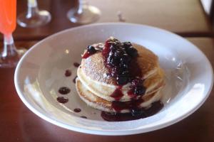 a plate of pancakes with berries on a table at Moringa Villa Honeymoon Suite in Mamin +47 photos