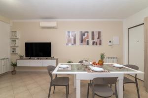 a living room with a white table and chairs at Colino APT in Olbia +9 photos