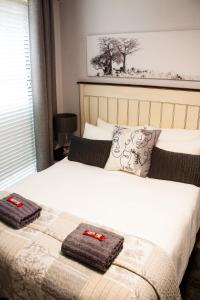 a bedroom with a bed with two towels on it at SantoSea in Mossel Bay