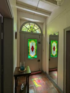 a hallway with a table and stained glass windows at Gîte de la Tour Donjon in Belcastel +13 photos