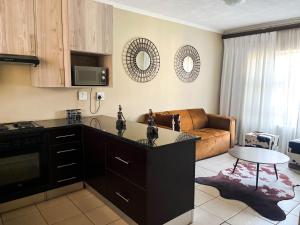 a kitchen and living room with a couch and a table at Tshamani self catering in Hazyview