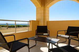 a room with chairs and a table and a window at Paliochora Beachfront Escape, Milolithos Pool Retreats in Palaiochora +36 photos