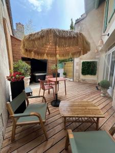 a patio with a table and chairs and an umbrella at Love Room L'Entre Nous in Thairé