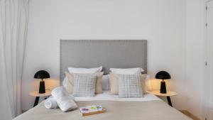 1 dormitorio con 1 cama con almohadas blancas y 2 lámparas en VACATION MARBELLA - Villa Federer, Old Town with a Big Communal Pool and Andalusian Garden, en Marbella 42 fotos más