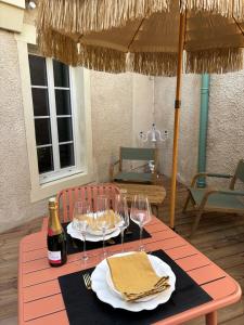 a table with two glasses and a bottle of wine at Love Room L'Entre Nous in Thairé