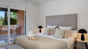 Un dormitorio con una cama grande con una ventana grande. en VACATION MARBELLA - Villa Federer, Old Town with a Big Communal Pool and Andalusian Garden, en Marbella