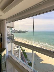 a room with a view of the beach and the ocean at 3 Dorm. Frente Mar com Churrasqueria #16 in Balneário Camboriú