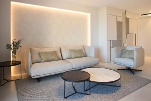a living room with a couch and a table and a chair at Insotel Fenicia Prestige Suites & Spa in Santa Eularia des Riu