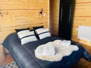 a large bed in a room with wooden walls at cabaña kupal in Junín de los Andes