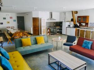a living room with three couches and a kitchen at Le gîte du Brusquet in Antrenas