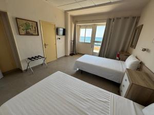 a hotel room with two beds and a balcony at Hotel Bahía by ALEGRIA in Puerto de Mazarrón