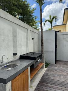a outdoor kitchen with a sink on a patio at Casa Malayka in Uluwatu