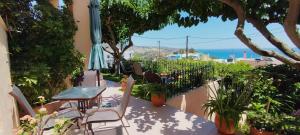 a patio with chairs and an umbrella and the ocean at Despoina Apartments in Keratokampos