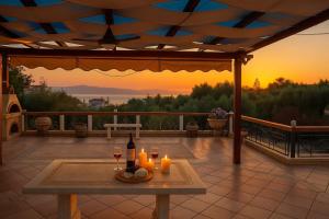stół z dwoma kieliszkami wina na patio w obiekcie Bianca Maisonette - Panoramic Golden View w Kalamácie