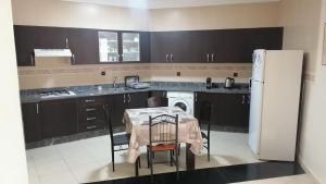 a kitchen with a table and a white refrigerator at la perle de tanger in Tangier