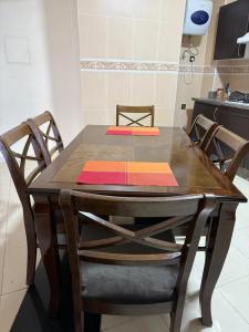 a wooden table with four chairs and a kitchen at la perle de tanger in Tangier