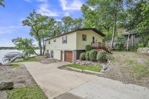 a house on the water with a driveway at The Lakeside Shack on West Lake Okoboji in Spirit Lake