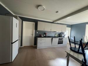 una cucina con elettrodomestici bianchi e pareti blu di Hus nær butikk, sentrum & rekreasjon a Hol