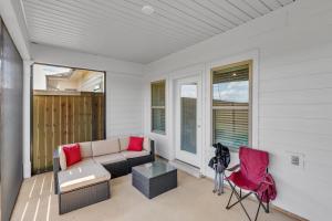 a porch with a couch and a table and chairs at Modern Nest - Huntsville Hideaway home in Huntsville