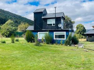 LologComplejo KUPAL的院子里有黑色屋顶的蓝色房子