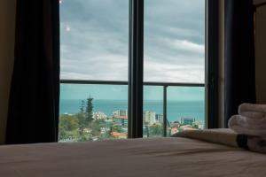 a bedroom with a bed and a large window at GuestReady - Homely stay in Funchal in Funchal