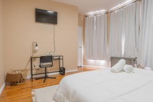 una camera da letto con un letto bianco e una televisione di NYC Train EWR Liberty Park 1 a Bayonne