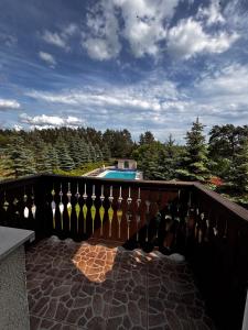 a balcony with a fence and a swimming pool at Villa Murano in Sajzy
