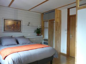 a bedroom with a large bed with an orange blanket at Loire Escale in Ancenis +1 photo