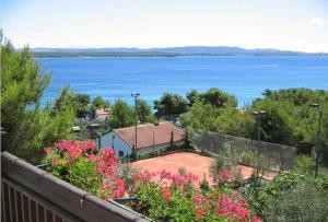 a house with a view of the water and flowers at Villa Milas - Apartman 01 in Tkon