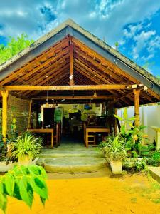 a house with a wooden roof with a patio at Diyakawa Hotel in Arugam Bay