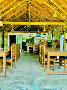 a dining room with wooden tables and chairs at Diyakawa Hotel in Arugam Bay +37 photos