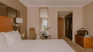 Un dormitorio con una gran cama blanca y una silla. en InterContinental Brisbane by IHG, en Brisbane 72 fotos más